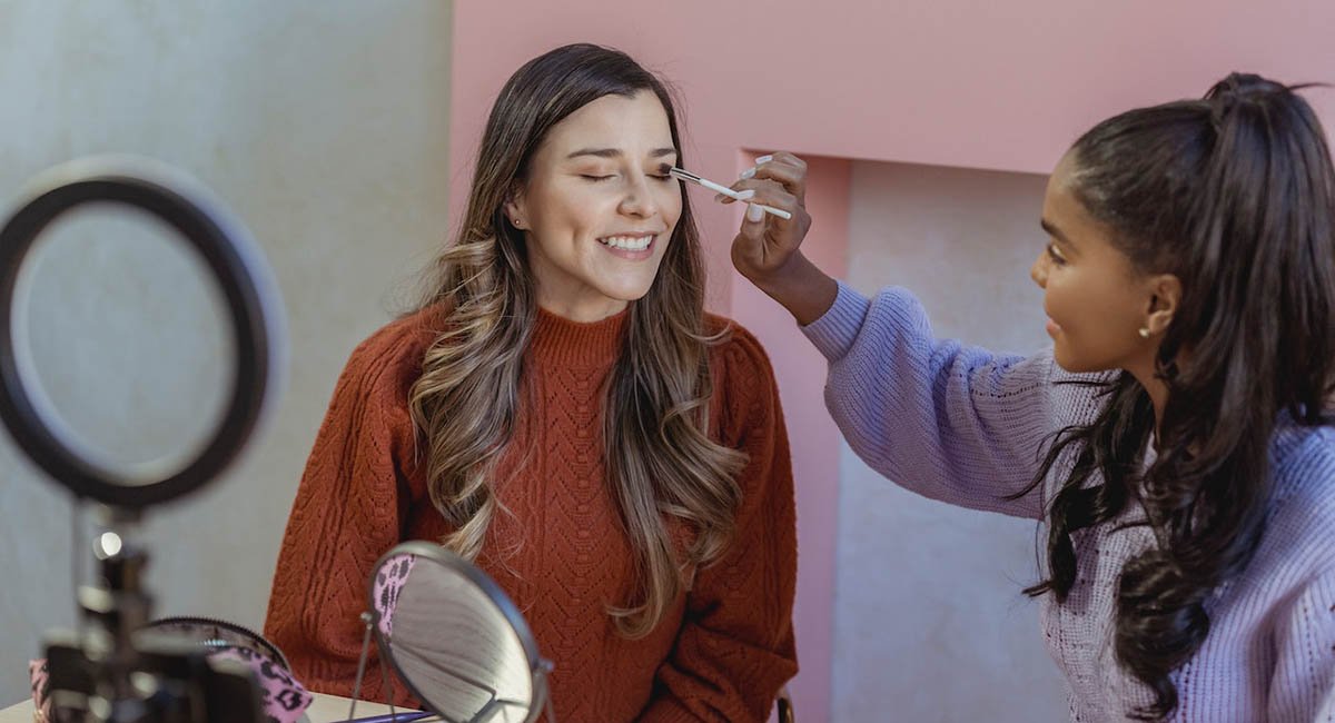 Let me show you how it looks! Beauty blogger applying makeup to another woman's face on social media