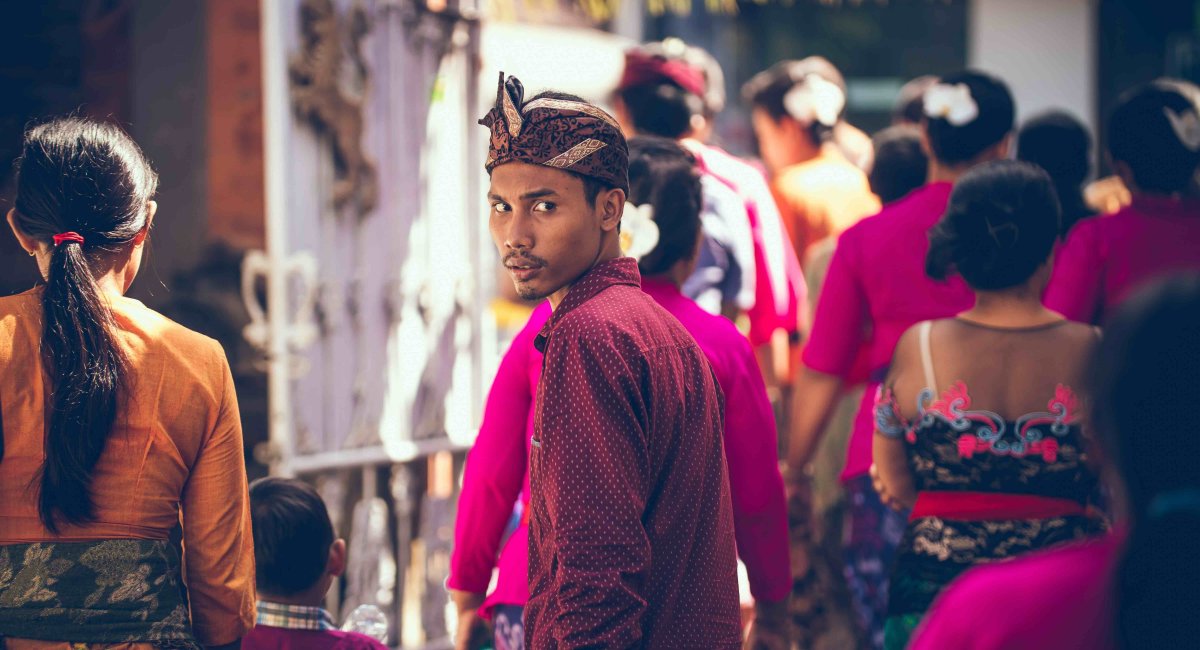 Review! Young man in a crowd looking back over his shoulder
