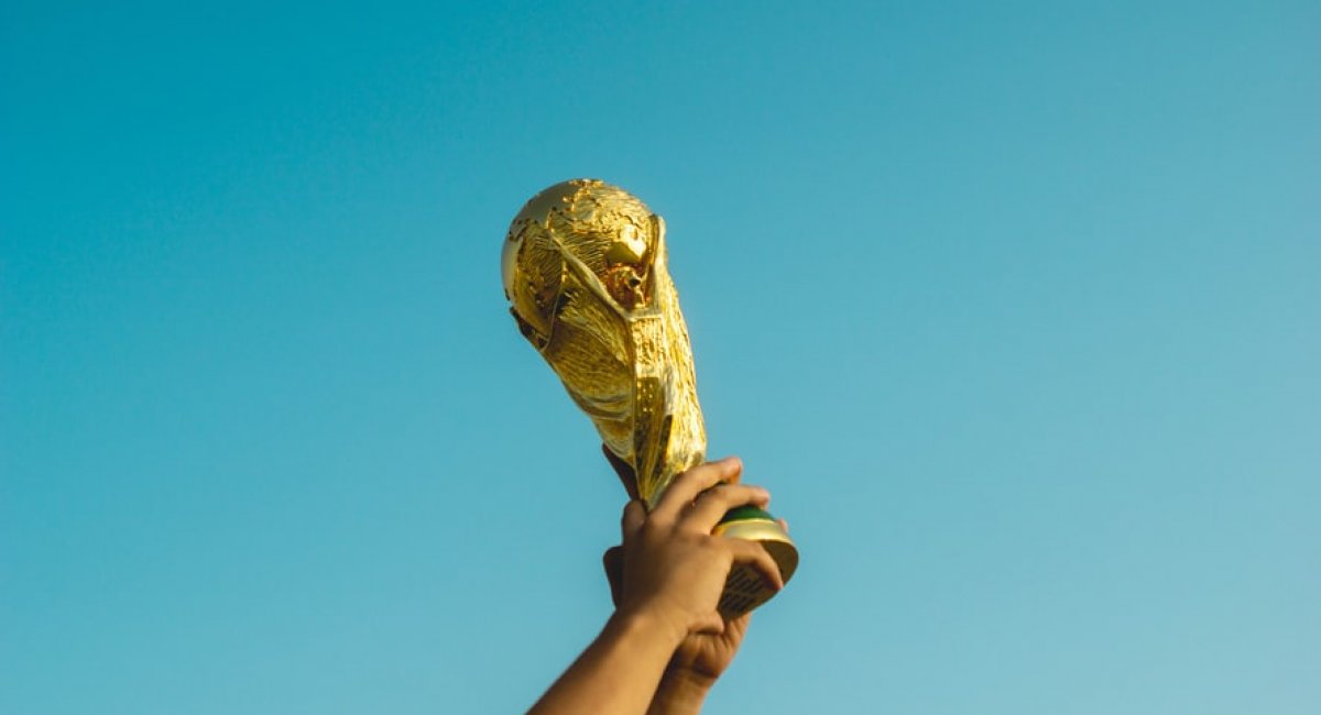 Hand holding a trophy up in the sky