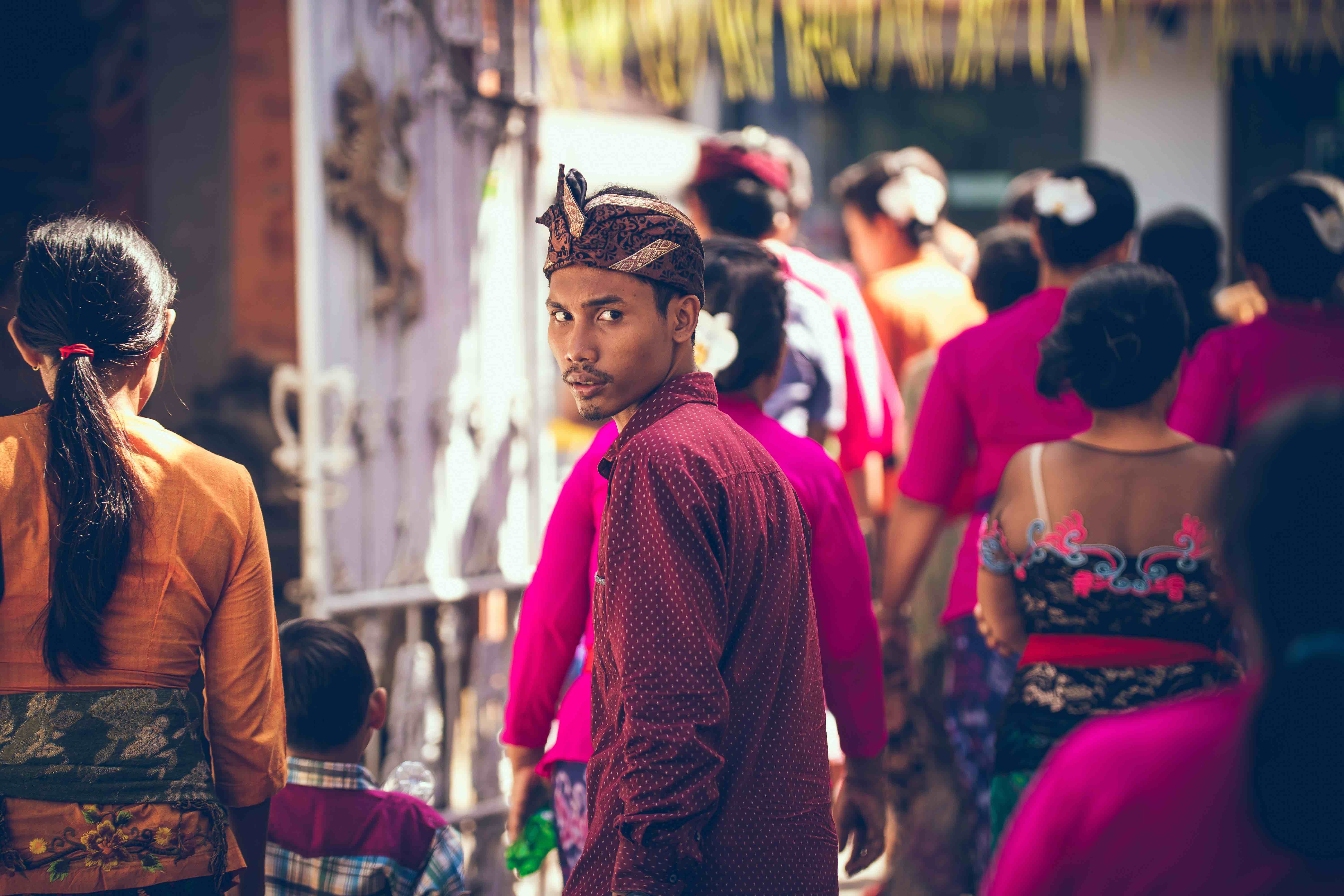 Young man in a crowd looking back over his shoulder