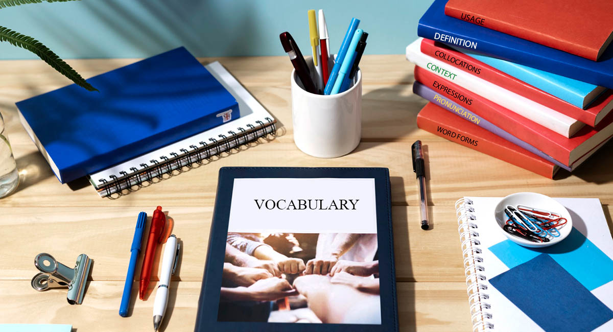 Books on desk with aspects of vocabulary on spine