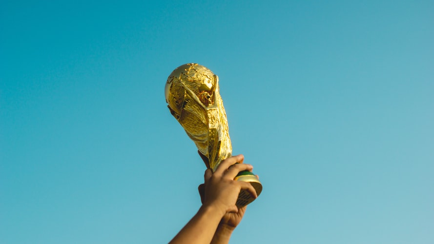 Hand holding a trophy up in the sky