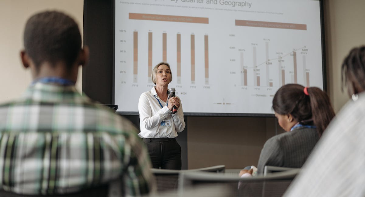 A woman presenting charts on projector screen