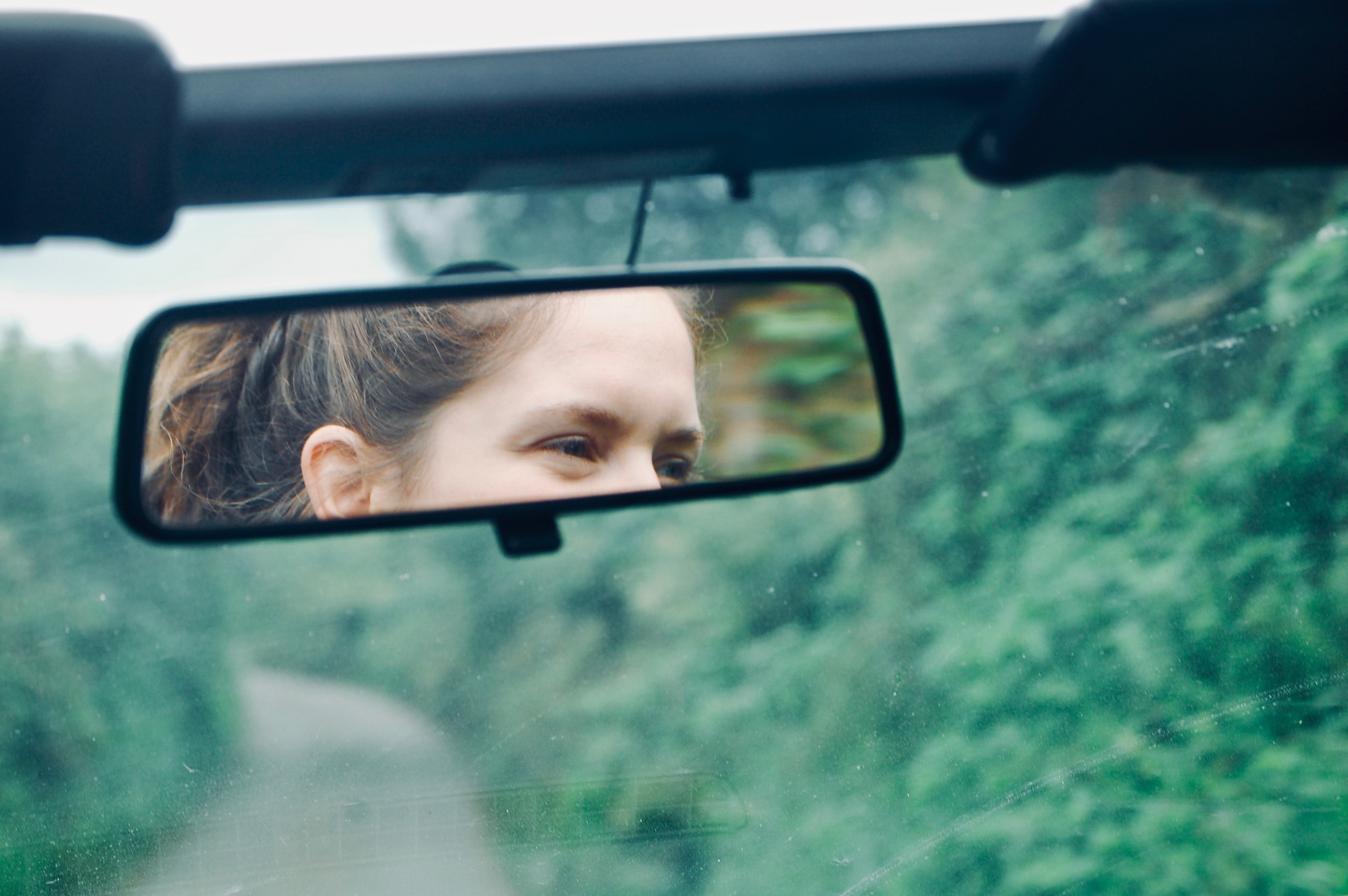 Woman's face in the rear view mirror of a car