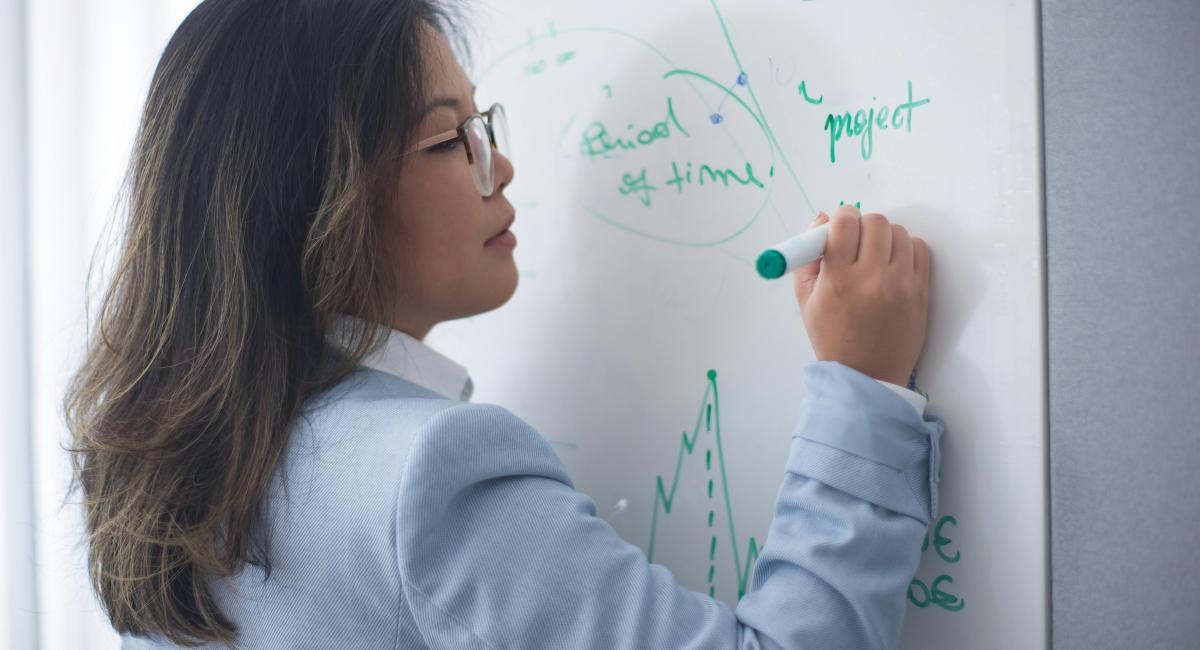 Woman analyzing information on a whiteboard