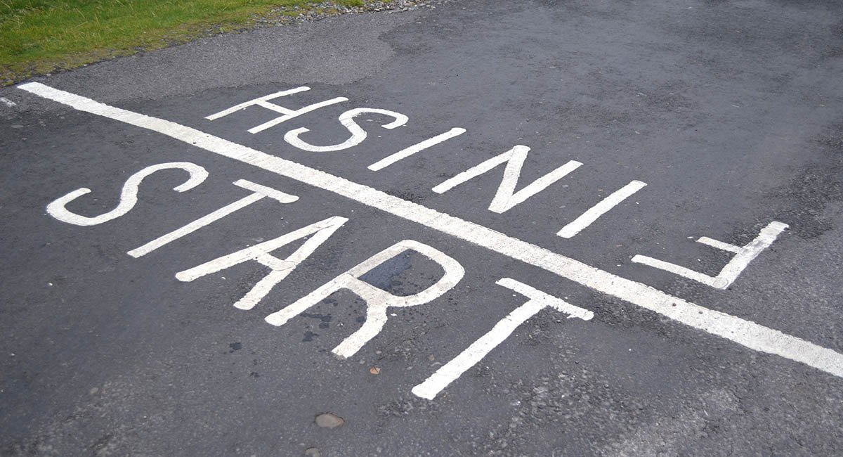 White words START and FINISH on either side of a line on gray pavement