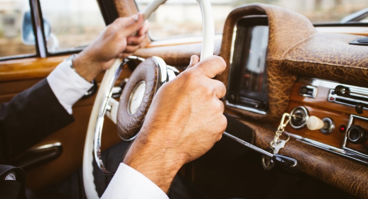 Man's hands on the steering wheel of a car